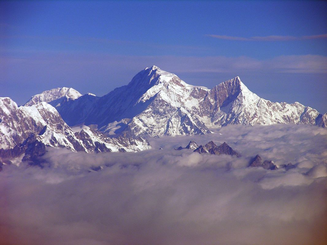 Kathmandu Mountain Flight 03-2 Shishapangma Shishapangma, the 14th highest mountain in the world at 8012m, shines in the early morning sun from Kathmandus Mountain flight. The steep and treacherous southwest face is in shadow on the left. The north face is just visible in the sun on the right. On the far right the pointy rocky peak is Phola Gangchen (7716m), first climbed in 1981, and to its left is Shishapangmas East face.